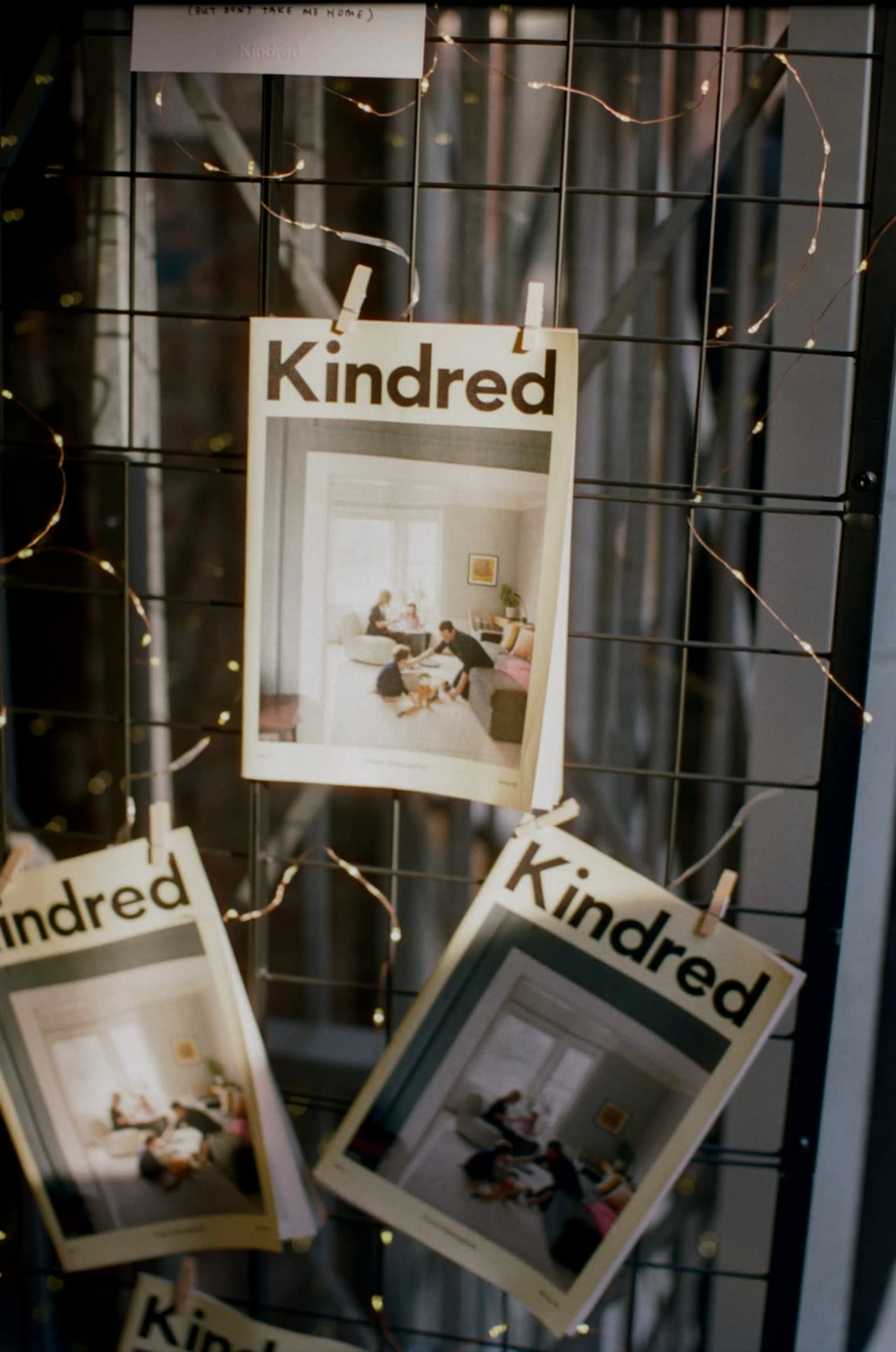Kindred posters pinned up among warm fairy lights.